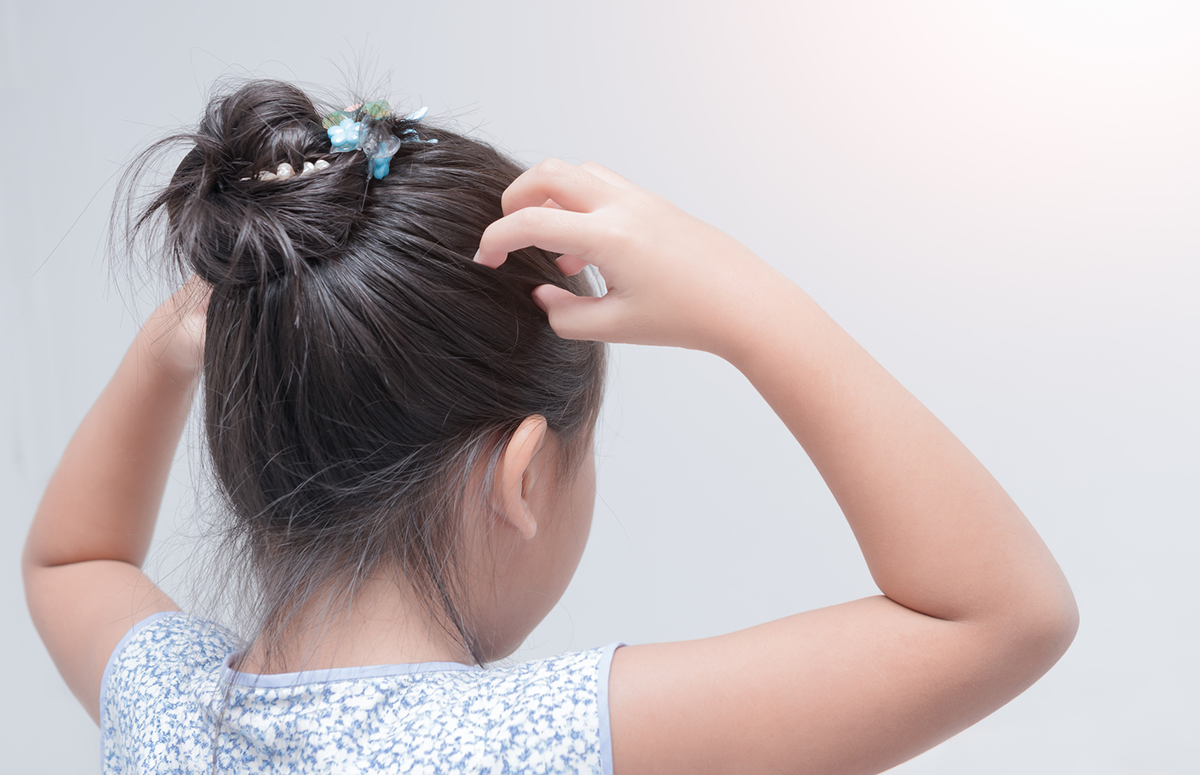 A young girl with her hair in her hand.